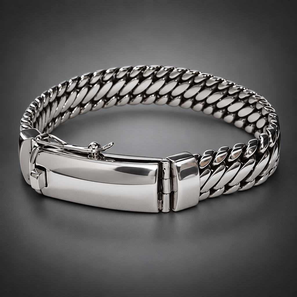 A silver-toned metal bracelet with a curb-style chain link design and a polished rectangular clasp, shown on a neutral gray background.