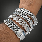 Close-up of a wrist wearing multiple silver bracelets with a blurred background