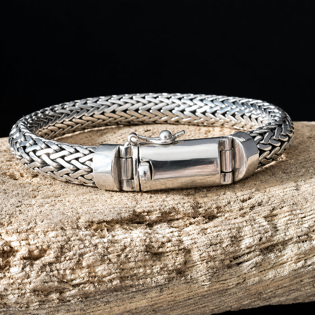 Silver braided bracelet on a wooden surface with a dark background