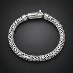 Silver braided bracelet on a hand against a dark background