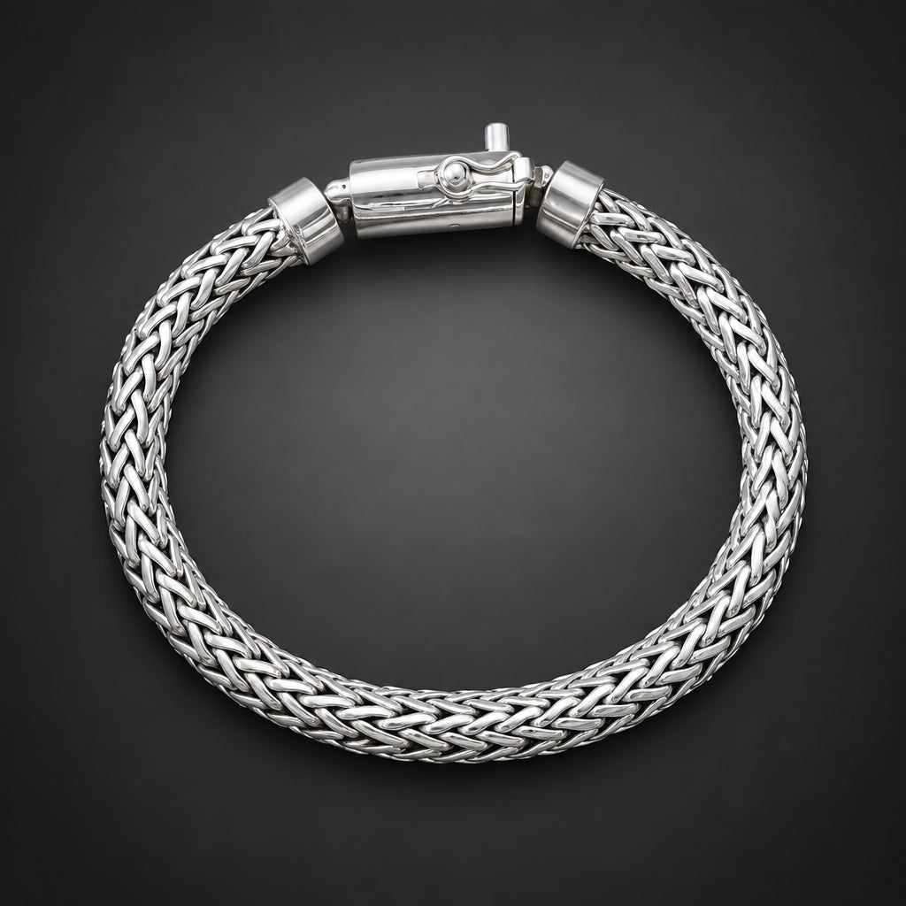 Silver braided bracelet on a hand against a dark background