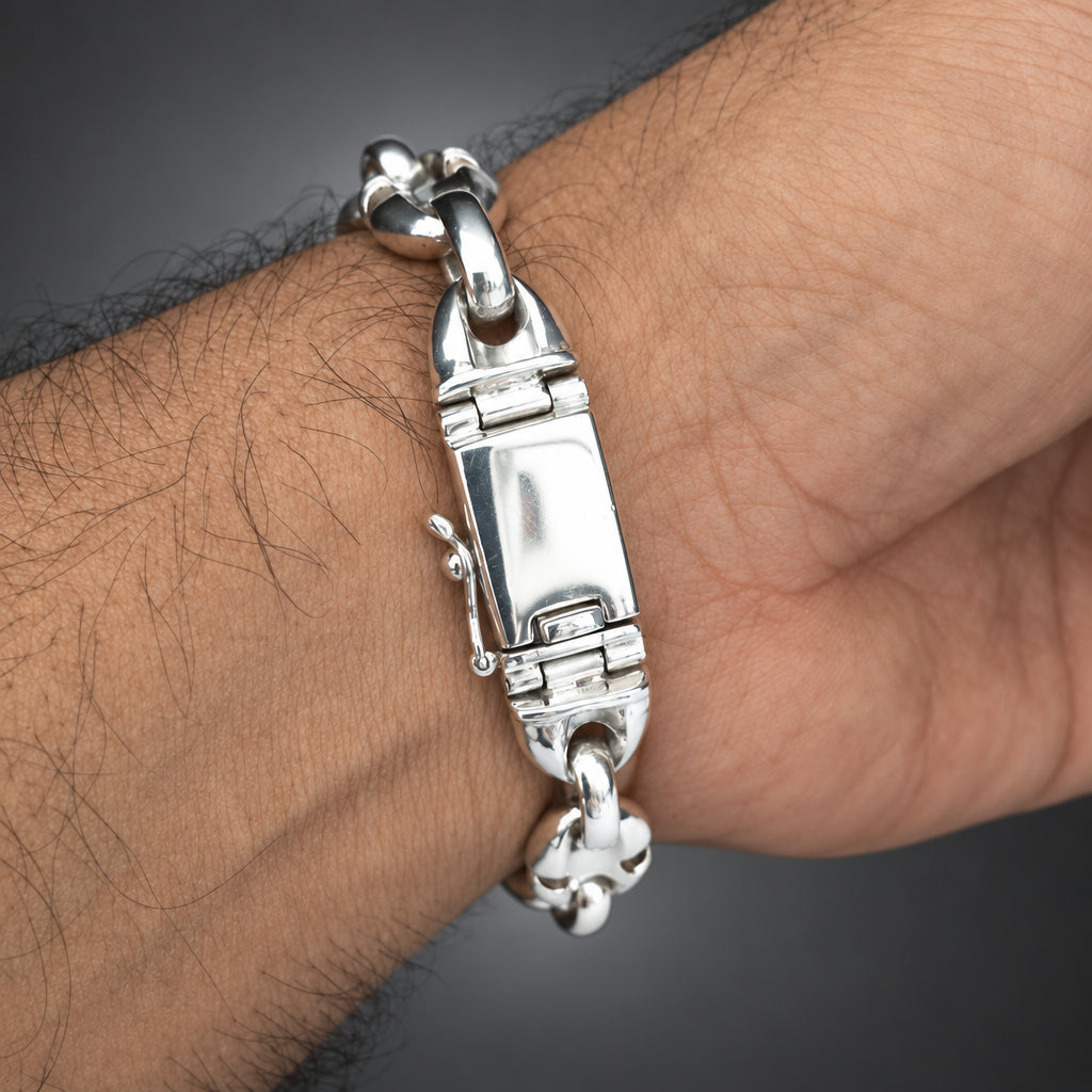 Silver bracelet on a wrist with a plain background