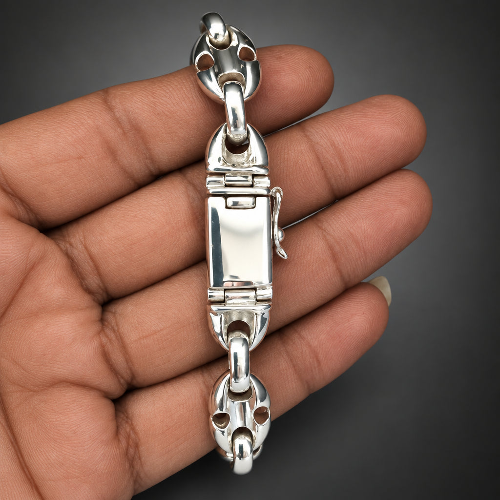 Silver bracelet on a hand against a plain background