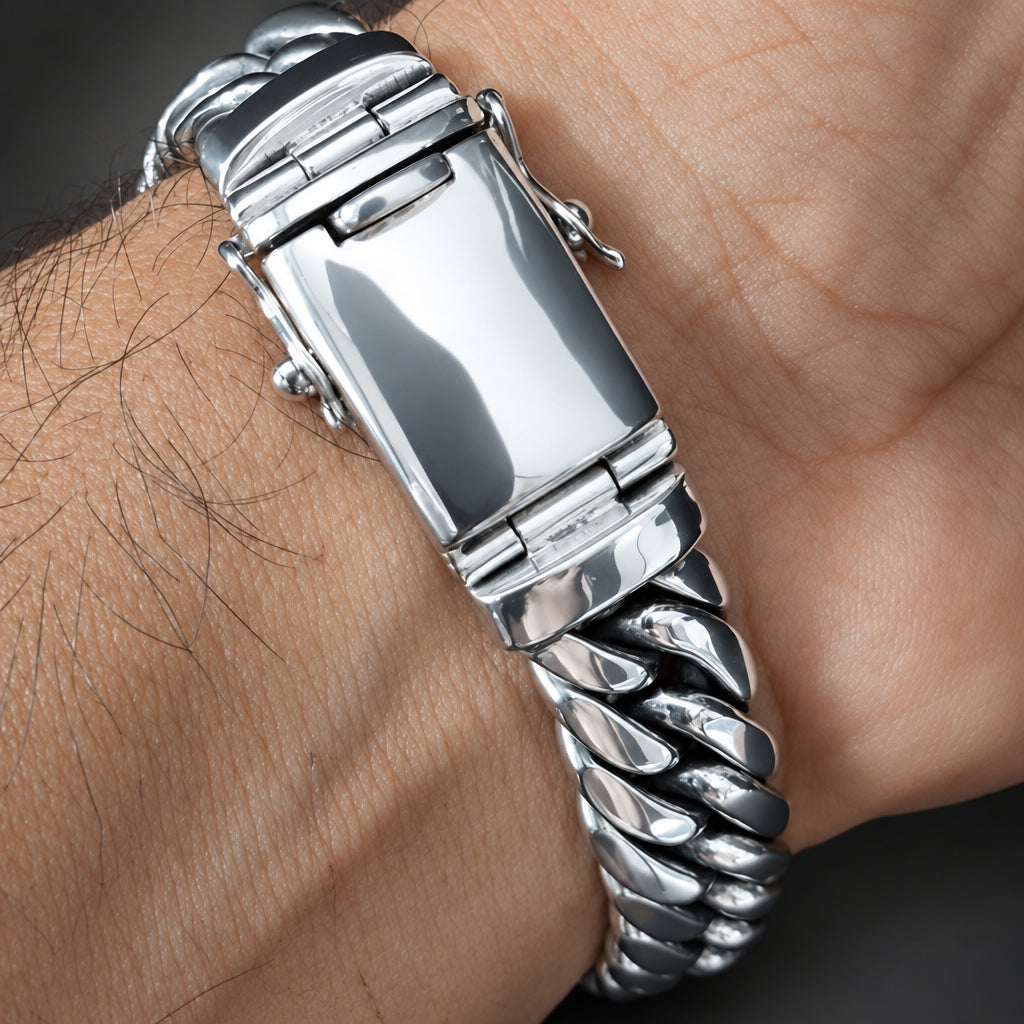 A close-up of a silver stainless steel link watch band worn on a person's wrist, showing the clasp and textured links.