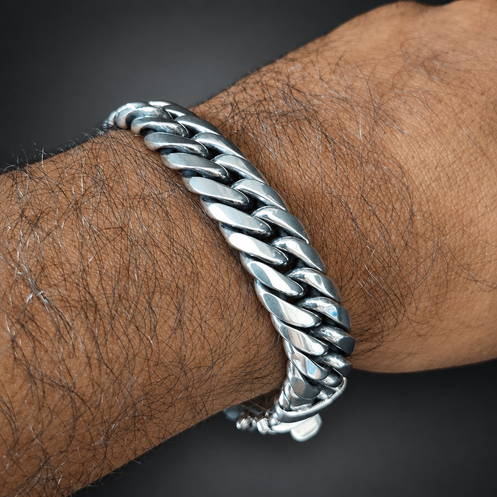 Silver chain bracelet on a wrist with a dark background