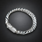 Silver bracelet on a hand against a dark background