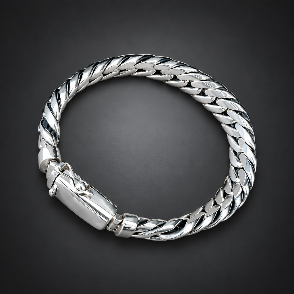 Silver bracelet on a hand against a dark background