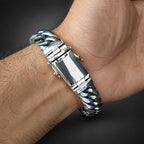 Silver bracelet on a wrist with a dark background