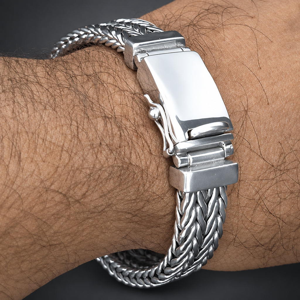 A silver-toned stainless steel magnetic bracelet with a braided link design, shown worn on a person's wrist.