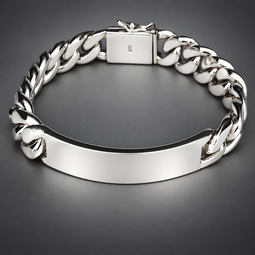 A silver-tone metal bracelet with a smooth central ID plate and a curb chain link design, shown on a dark background.