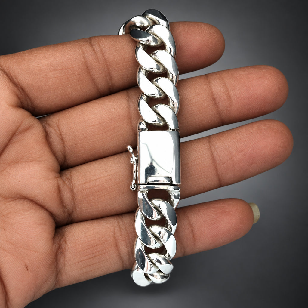 Silver braided bracelet held in a hand against a gradient dark background