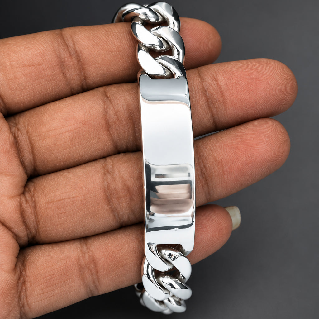 Silver chain bracelet on a hand against a dark background