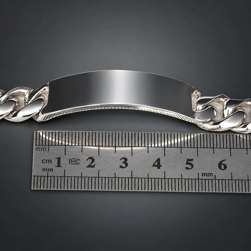 Silver bracelet with a ruler for scale on a dark background