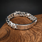 Silver chain bracelet on a wooden surface with a dark background
