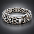 Silver bracelet with intricate design on a dark grey gradient background
