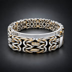Silver and black braided bracelet on a dark background