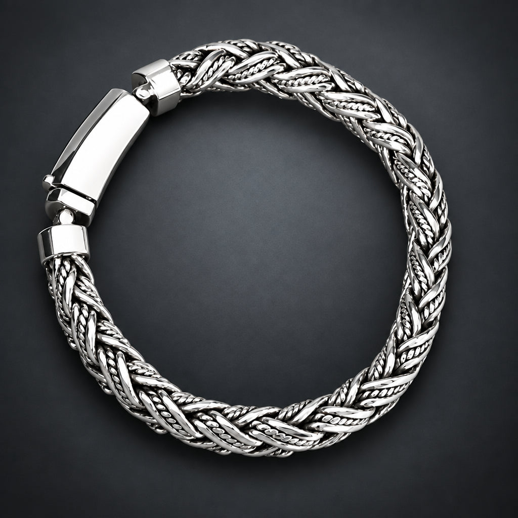 Silver braided bracelet on a hand with a gradient dark grey background