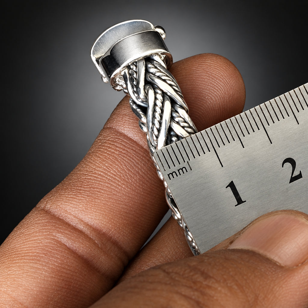 Silver ring being worn on a finger with a ruler for size reference.
