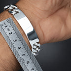 Silver bracelet on a wrist with a ruler for size reference
