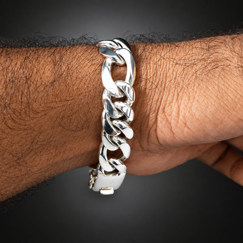 Silver chain bracelet on a wrist against a dark background