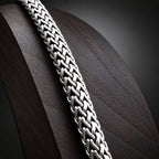 Close-up of a silver chain on a textured surface