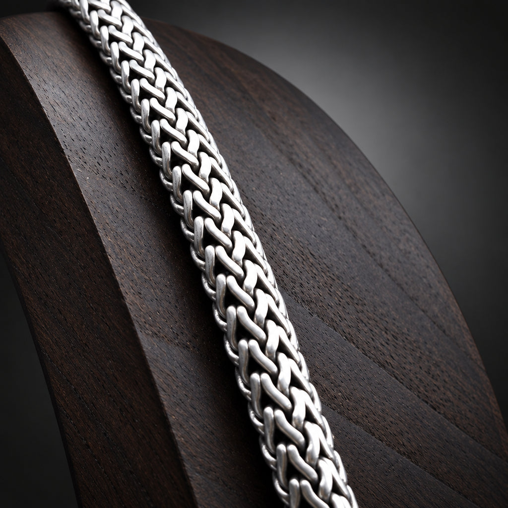 Close-up of a silver chain on a textured surface
