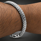 Silver bracelet with a braided design on a wrist.