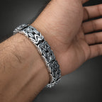 Silver chain bracelet on a wrist with a blurred background