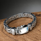 Silver bracelet with a textured band on a wooden surface