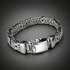 Silver bracelet with a textured band on a wooden surface