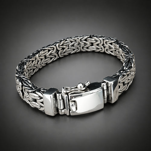 Silver bracelet with a textured band on a wooden surface