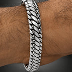 Silver chain bracelet on a wrist with a blurred background