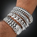 Close-up of a wrist wearing multiple silver bracelets with a blurred background