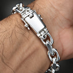 A close-up of a silver metal link bracelet worn on a person's wrist, showing the clasp and chain links against skin.