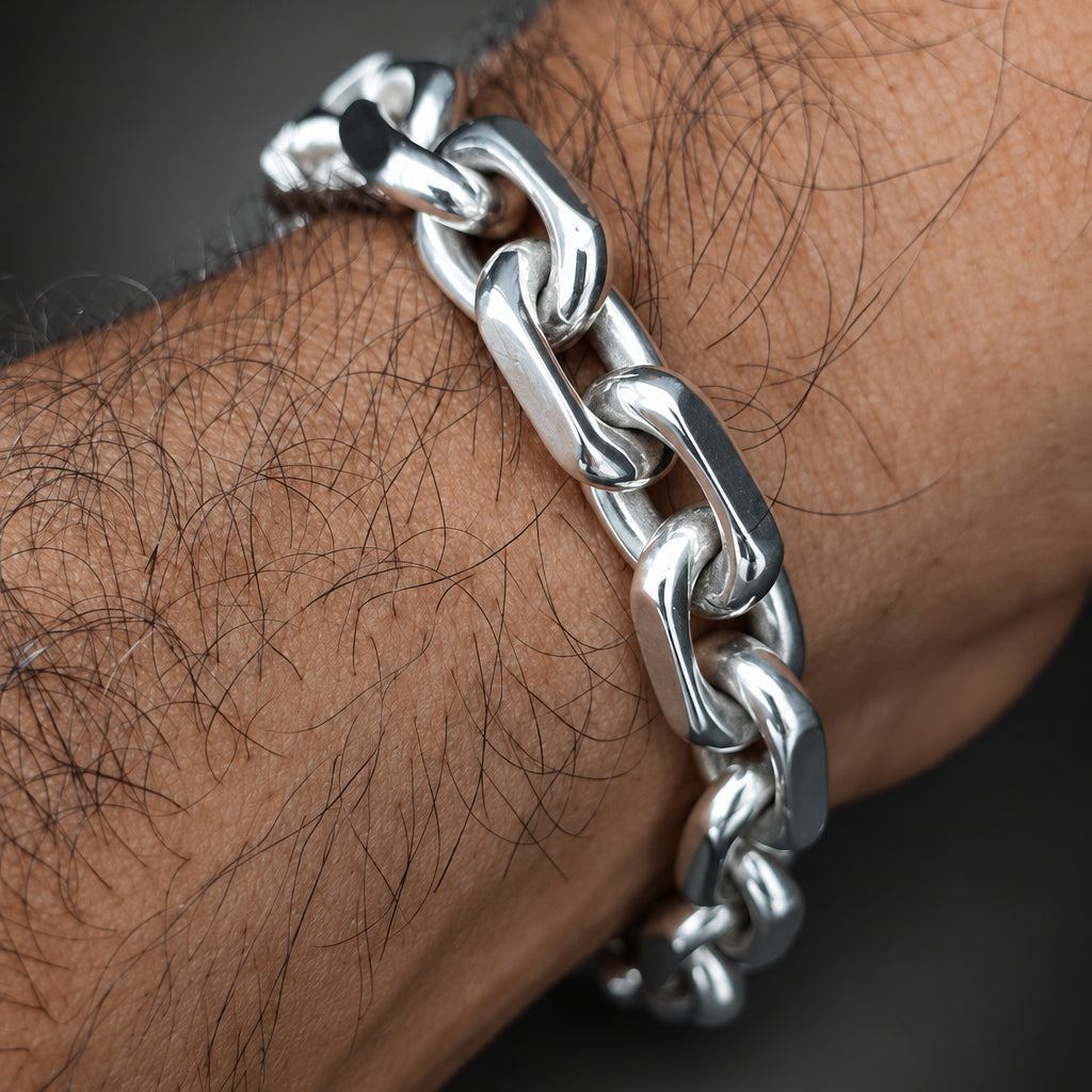 Silver chain bracelet on a wrist with a dark background