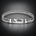 A silver-toned braided chain bracelet with a polished clasp, displayed on a neutral light gray background.
