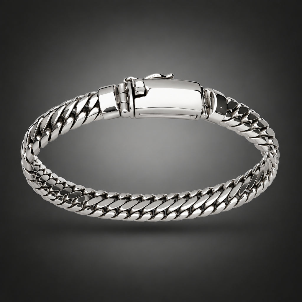 A silver-toned metal chain-link bangle bracelet held by a hand against a plain light gray background.