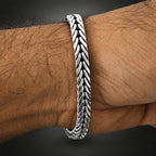 Silver bracelet on a wrist against a white background