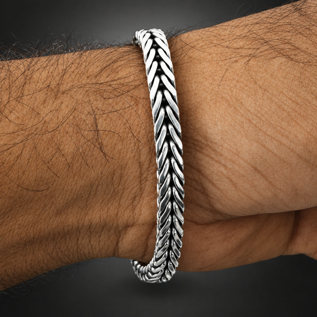 Silver bracelet on a wrist against a white background