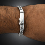 Silver bracelet on a wrist with a white background