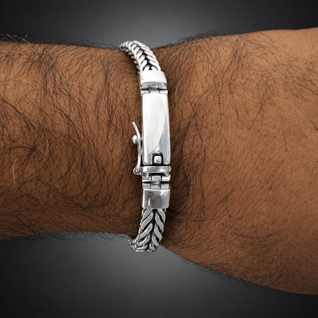 Silver bracelet on a wrist with a white background