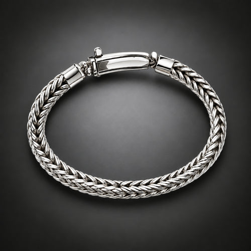 A silver braided cable bracelet with a polished clasp, displayed on a dark gray gradient background.