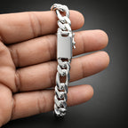 Silver chain bracelet held in a hand against a neutral background