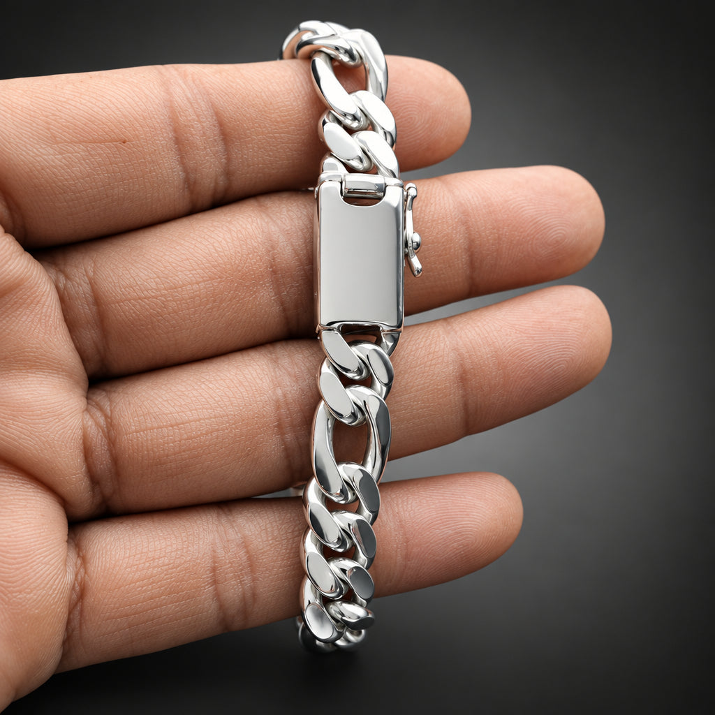Silver chain bracelet held in a hand against a neutral background
