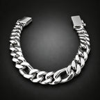 A chunky silver-tone Cuban link bracelet with a polished finish, displayed in a U-shape on a dark gray gradient background.