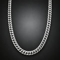 A silver-toned Cuban link chain necklace arranged in a U-shape against a dark gray gradient background.