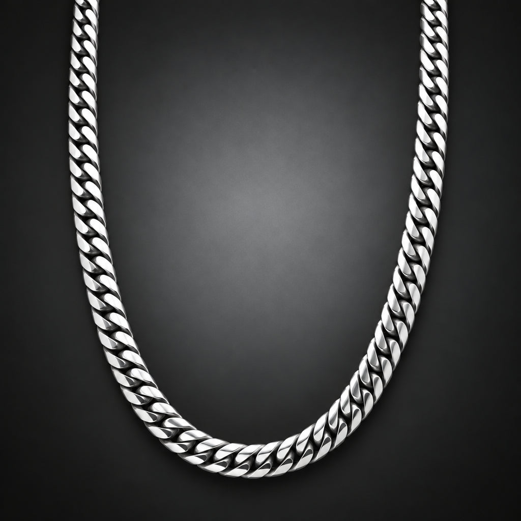 A silver-toned Cuban link chain necklace arranged in a U-shape against a dark gray gradient background.