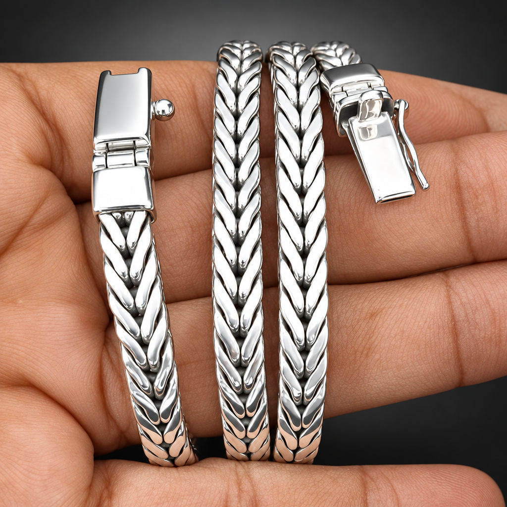 Three silver-toned textured bangles with chevron and leaf-like patterns, displayed on a person's hand against a dark background.