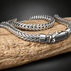 Silver braided bracelet with a clasp on a wooden surface