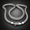 Silver braided bracelet on a wooden surface with a dark background